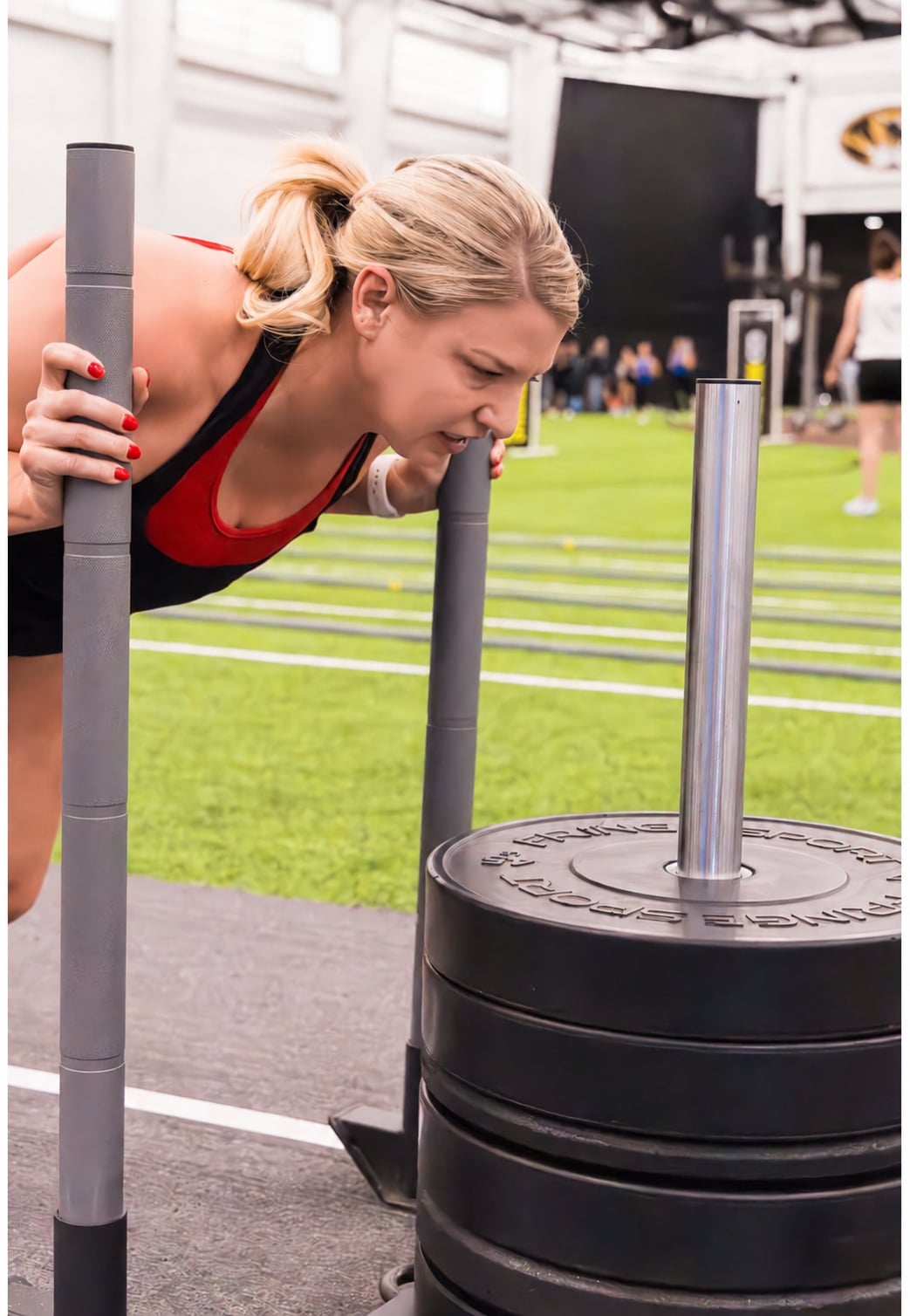 Rachel pushing a weighted sled during a gym workout